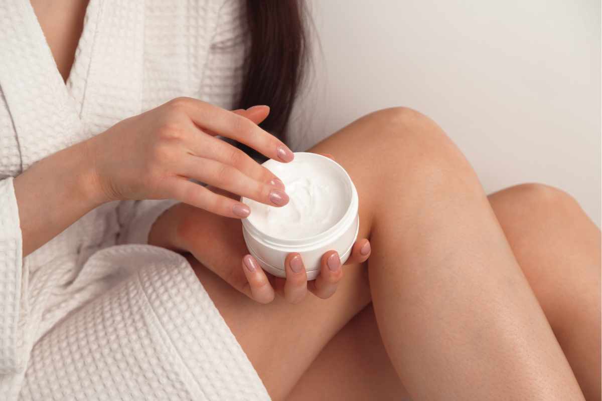 Woman applying cellulite cream to her legs to improve skin firmness and reduce visible dimpling