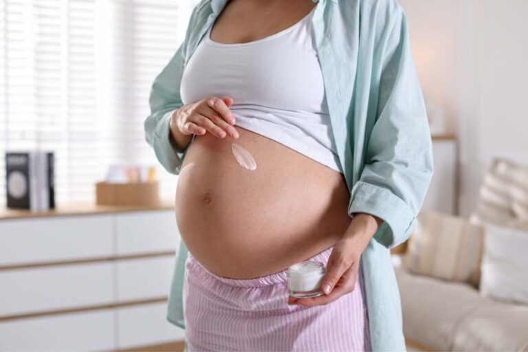 Pregnant woman applying moisturiser to her belly as part of a Tissue Oils skincare routine to support skin hydration and elasticity.