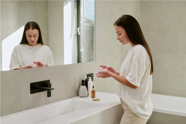 Woman applying moisturiser as part of an HA Contour Masque winter skincare routine for lasting hydration.
